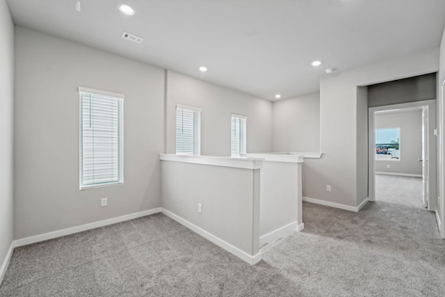 spare room featuring light carpet and a wealth of natural light