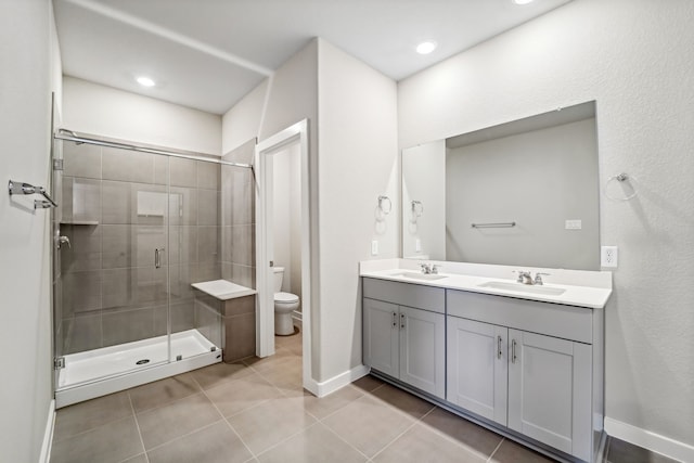 bathroom with tile patterned flooring, vanity, toilet, and a shower with shower door