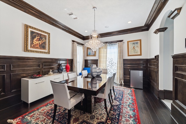 dining room with crown molding, a chandelier, and dark hardwood / wood-style flooring