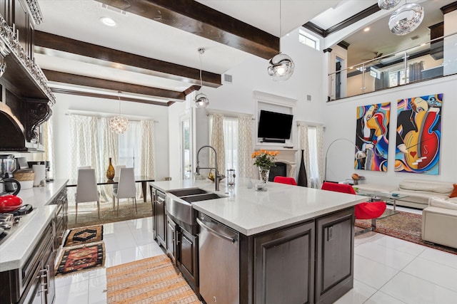 kitchen featuring a kitchen island with sink, stainless steel appliances, hanging light fixtures, and sink