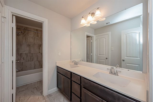 bathroom with tiled shower / bath and vanity