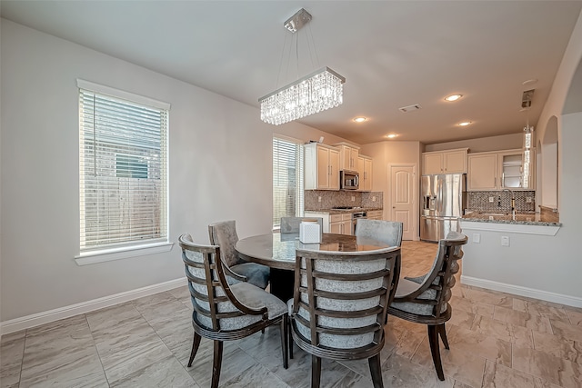 dining area featuring a notable chandelier, sink, and a wealth of natural light