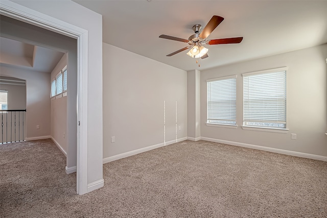 carpeted spare room featuring ceiling fan