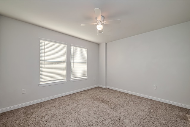 carpeted spare room featuring ceiling fan