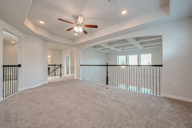 carpeted spare room featuring ceiling fan, a tray ceiling, and coffered ceiling