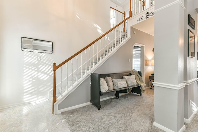 stairway with plenty of natural light and carpet flooring