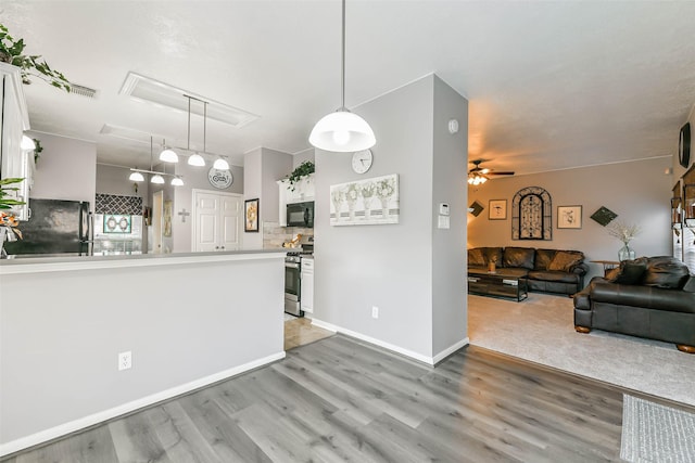 kitchen with pendant lighting, ceiling fan, backsplash, white cabinetry, and black appliances