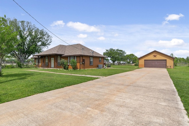 view of front facade with a garage, a front yard, and an outbuilding