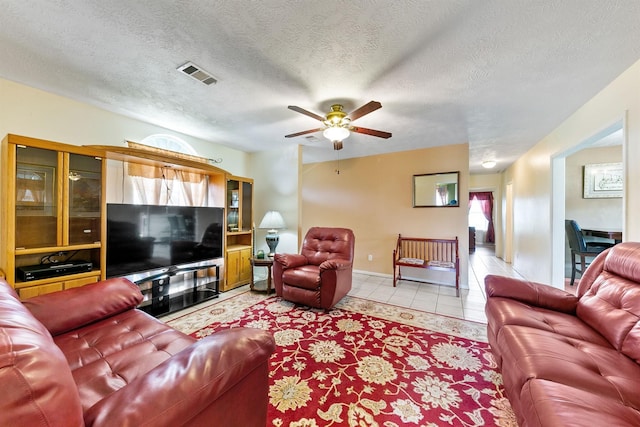 tiled living room featuring ceiling fan and a textured ceiling