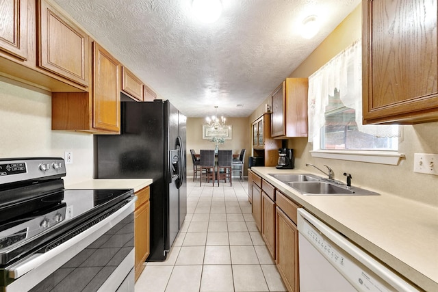 kitchen featuring pendant lighting, sink, white dishwasher, stainless steel electric range, and a textured ceiling