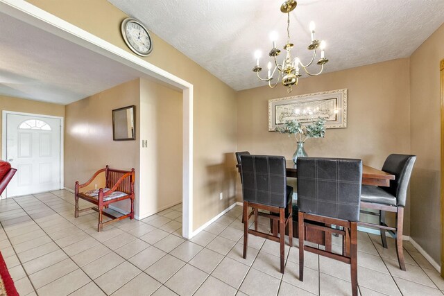 tiled dining room with an inviting chandelier and a textured ceiling