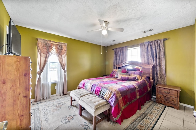 bedroom featuring a textured ceiling, multiple windows, and ceiling fan