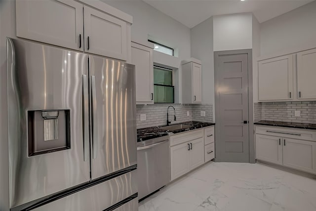 2322 Tuam, Houston, TX 77004 - kitchen featuring appliances with stainless steel finishes, backsplash, light marble finish floors, white cabinets, and dark stone counters