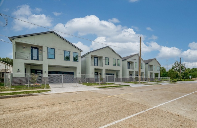 2322 Tuam, Houston, TX 77004 - multi unit property featuring a fenced front yard, driveway, stucco siding, and an attached garage