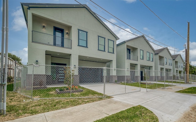 2322 Tuam, Houston, TX 77004 - view of front of property featuring a fenced front yard, a balcony, stucco siding, a carport, and a residential view