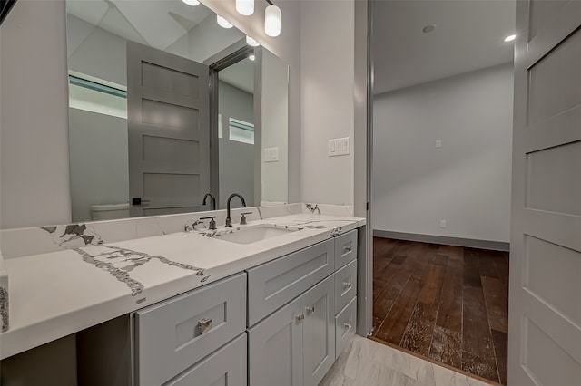 bathroom featuring vanity, plenty of natural light, toilet, and hardwood / wood-style flooring