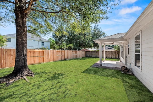 view of yard featuring ceiling fan and a patio