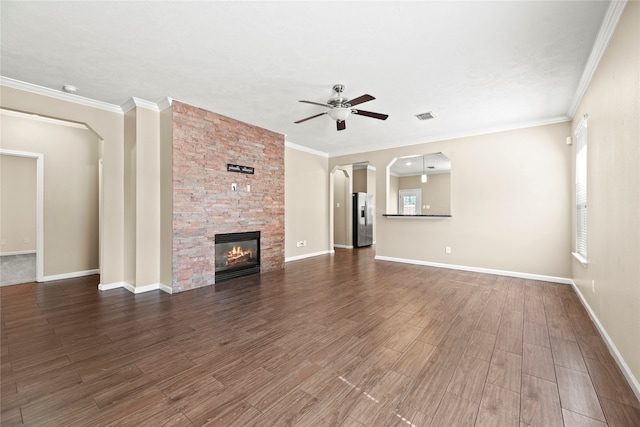 unfurnished living room featuring ceiling fan, ornamental molding, and a stone fireplace