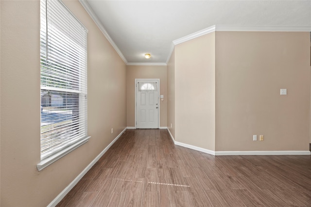 foyer entrance with ornamental molding and hardwood / wood-style floors