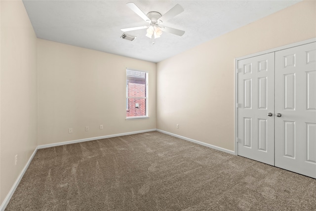 unfurnished bedroom with ceiling fan, a closet, and carpet floors