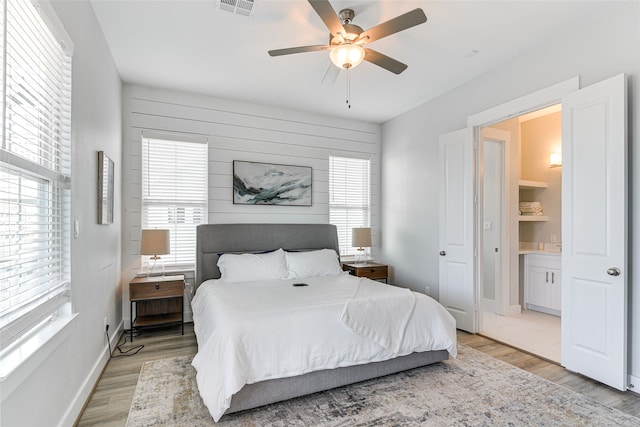 bedroom featuring ensuite bath, ceiling fan, and light hardwood / wood-style floors