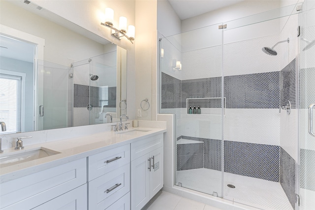 bathroom with vanity, a shower with shower door, and tile patterned floors