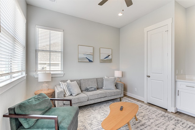 living room with light hardwood / wood-style flooring and ceiling fan