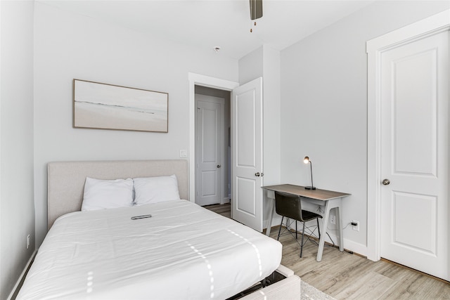 bedroom featuring ceiling fan, built in desk, and light hardwood / wood-style flooring