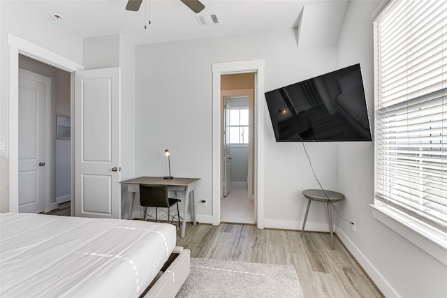 bedroom with connected bathroom, light wood-type flooring, and ceiling fan