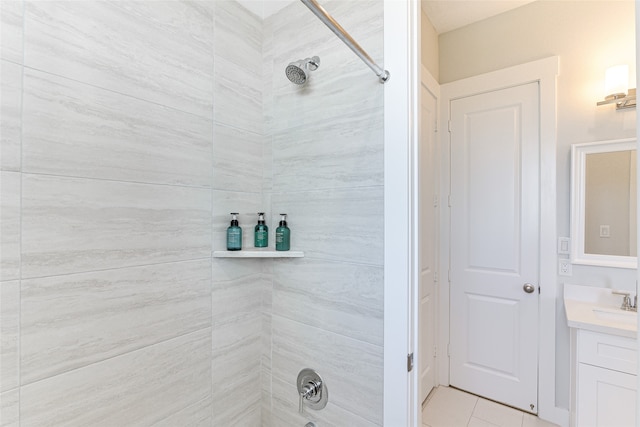 bathroom with tile patterned floors, tiled shower, and vanity