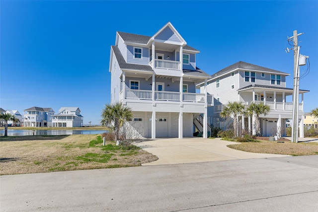 beach home featuring a balcony, a garage, and a water view