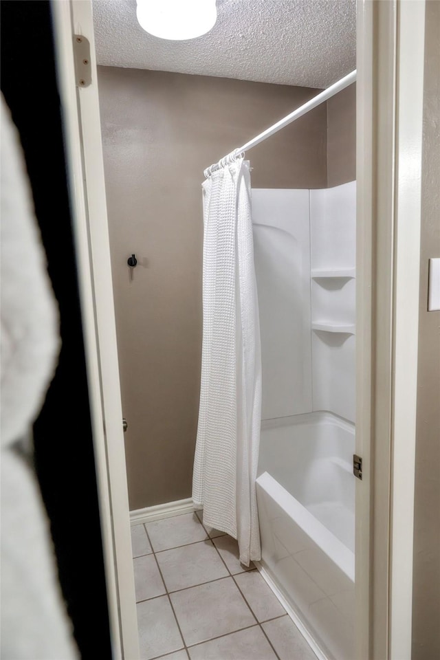 bathroom with tile patterned flooring, a textured ceiling, and shower / bathtub combination with curtain