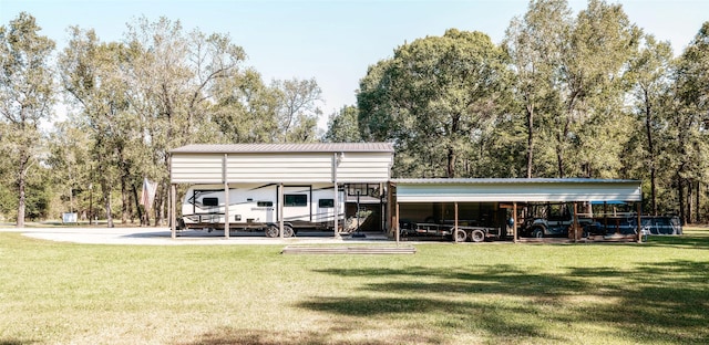 back of property with a carport and a yard