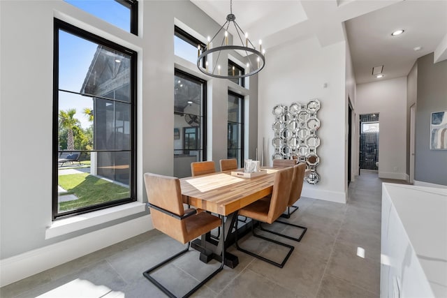 dining room with coffered ceiling, a towering ceiling, beam ceiling, and a chandelier