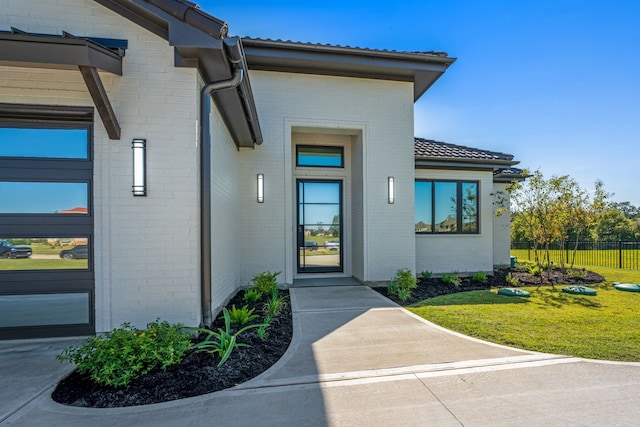 property entrance featuring a lawn