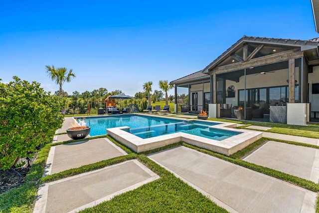 view of swimming pool featuring an in ground hot tub, a patio, and a sunroom