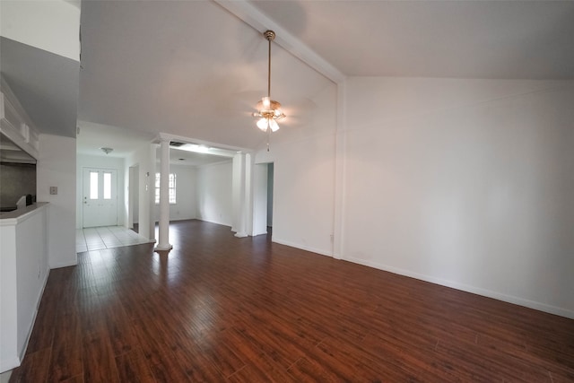 unfurnished living room featuring ceiling fan, vaulted ceiling with beams, decorative columns, and dark hardwood / wood-style flooring