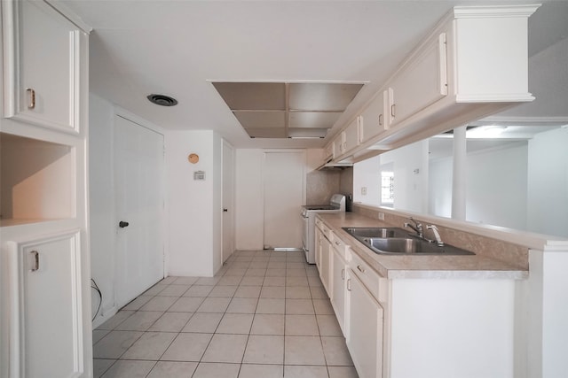 kitchen featuring white cabinets, sink, kitchen peninsula, white range, and light tile patterned floors