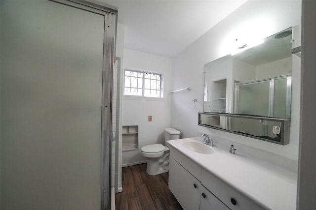 bathroom with an enclosed shower, hardwood / wood-style floors, vanity, and toilet