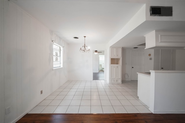 empty room with an inviting chandelier and light hardwood / wood-style floors