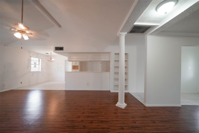 unfurnished living room with ceiling fan, lofted ceiling, wood-type flooring, a textured ceiling, and decorative columns