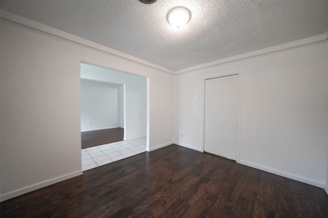 unfurnished room with hardwood / wood-style flooring and a textured ceiling