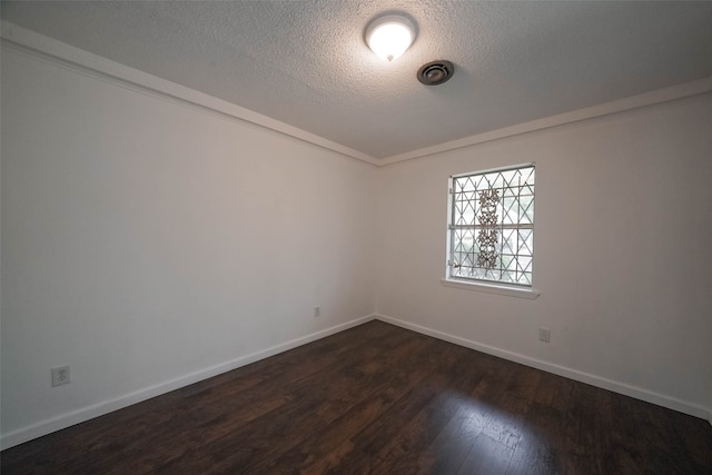 empty room with dark hardwood / wood-style floors and a textured ceiling