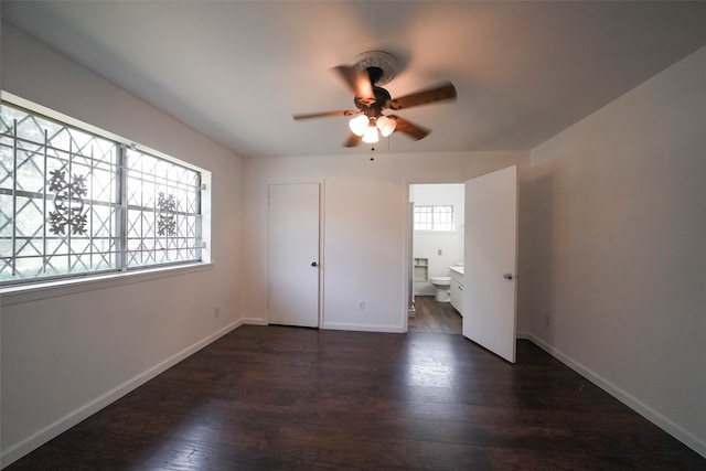 unfurnished bedroom featuring a closet, dark hardwood / wood-style floors, ensuite bathroom, and ceiling fan