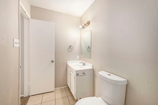 bathroom with tile patterned flooring, vanity, and toilet