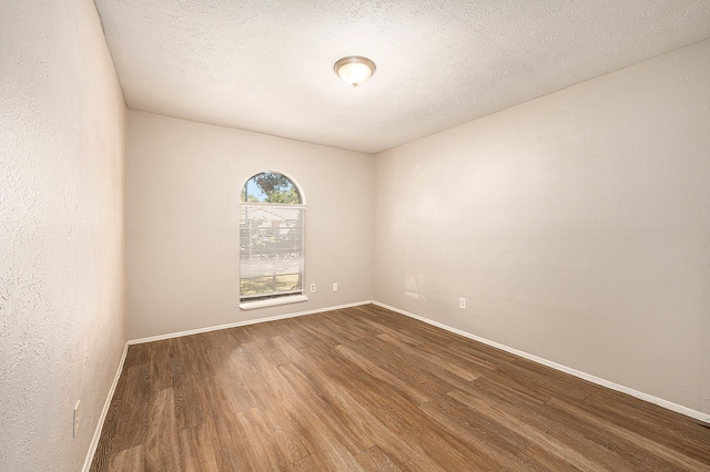 unfurnished room featuring hardwood / wood-style floors and a textured ceiling