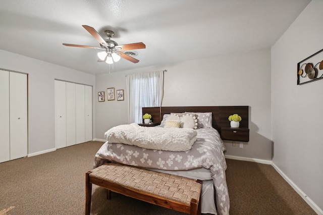 bedroom featuring dark colored carpet, multiple closets, and ceiling fan