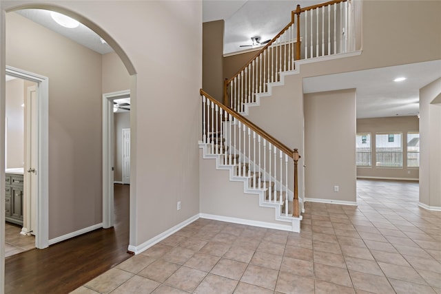 staircase with tile patterned floors and ceiling fan