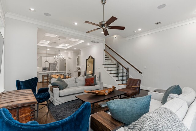 living room with wood-type flooring, ceiling fan with notable chandelier, crown molding, and coffered ceiling