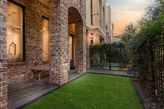 yard at dusk featuring a patio